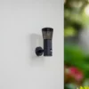 Aplique de exterior Lindby Heulo, Ø 10,5 cm, gris humo, con sensor