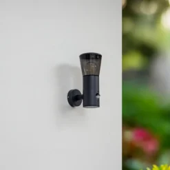Aplique de exterior Lindby Heulo, Ø 10,5 cm, gris humo, con sensor