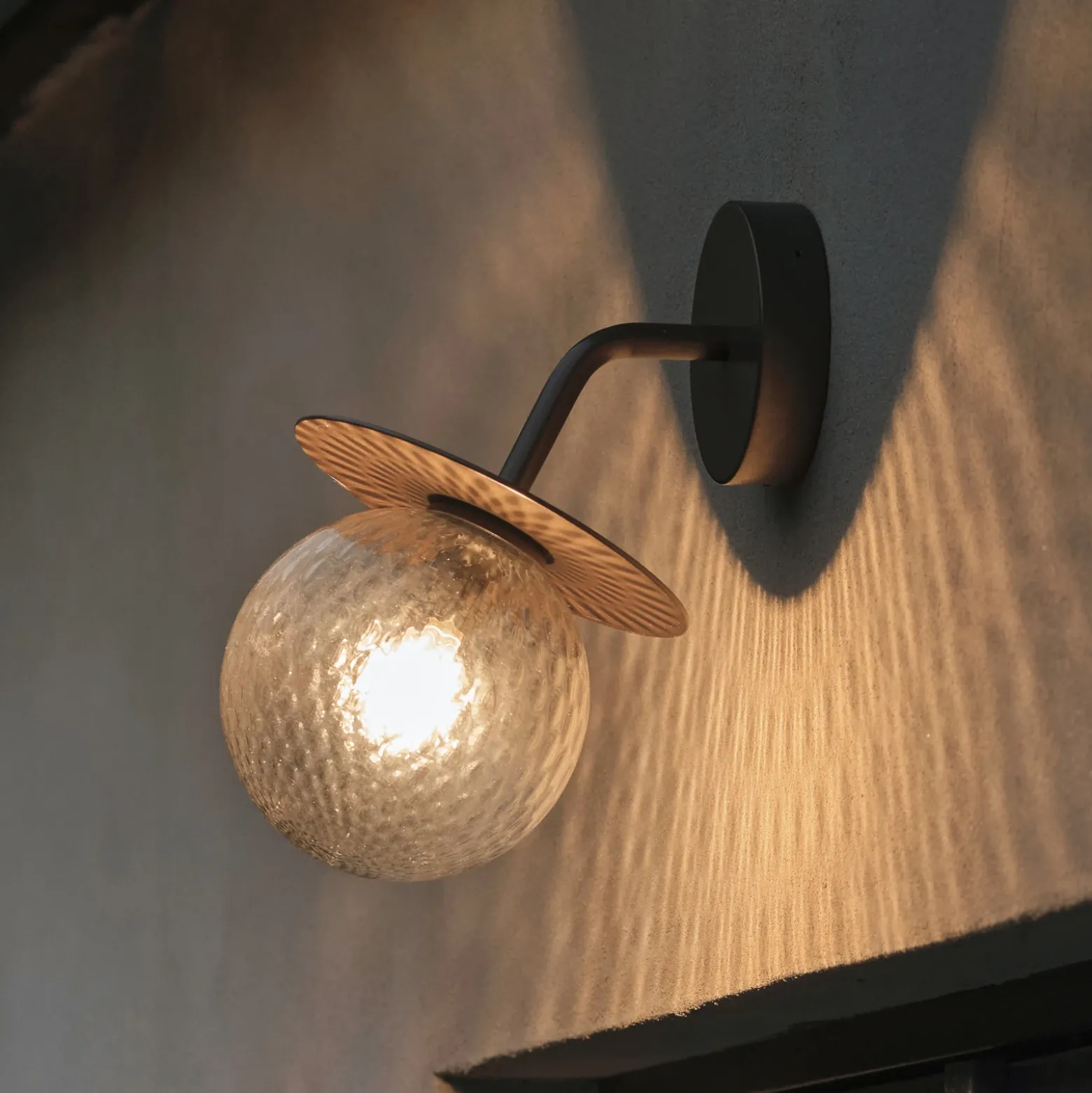 Aplique de exterior Nuura Liila, ancho 16 cm, bronce/transparente