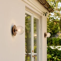 Aplique de exterior Nuura Liila, Ø 16 cm, bronce/transparente