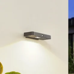 Aplique de pared LED solar Lucande Tavon, angular, negra, con sensor