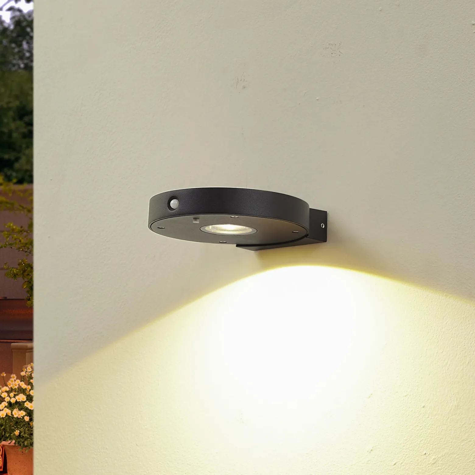 Aplique de pared LED solar Lucande Tavon, redondo, negro, sensor