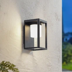 Aplique de pared solar LED Lucande Tilena, negra, aluminio, sensor