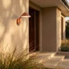 Aplique LED para exterior Lindby Capelo, color tierra, Ø 20 cm, con sensor