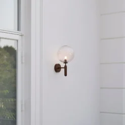 Aplique para exterior Nuura Miira, Ø 20 cm, bronce oscuro/transparente