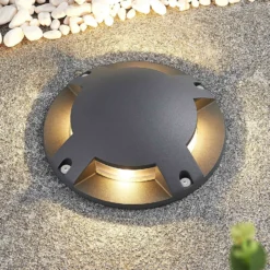 Lindby foco LED de suelo Cormac, 4 luces, Ø 21 cm, IP67